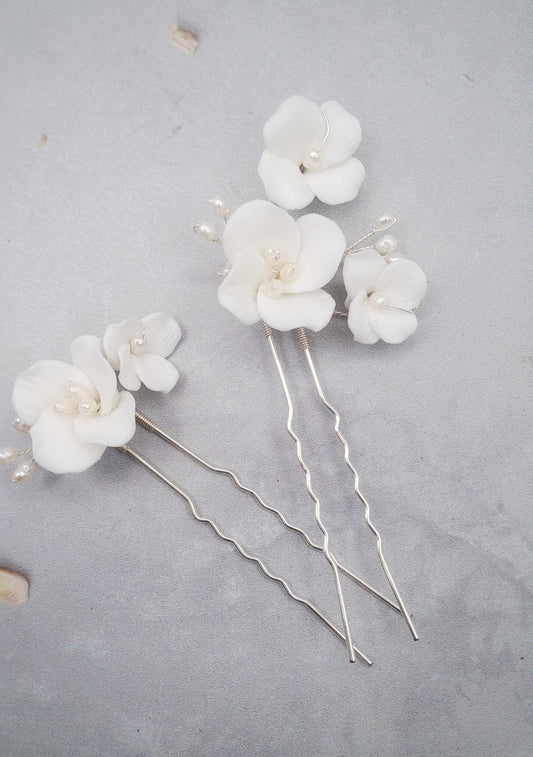 Set of two gold Salina floral hair pins with delicate white flowers for formal and bohemian hairstyles