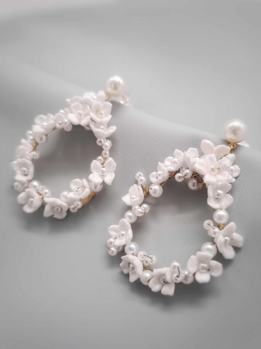 Pair of pearl hoop earrings on a gray background