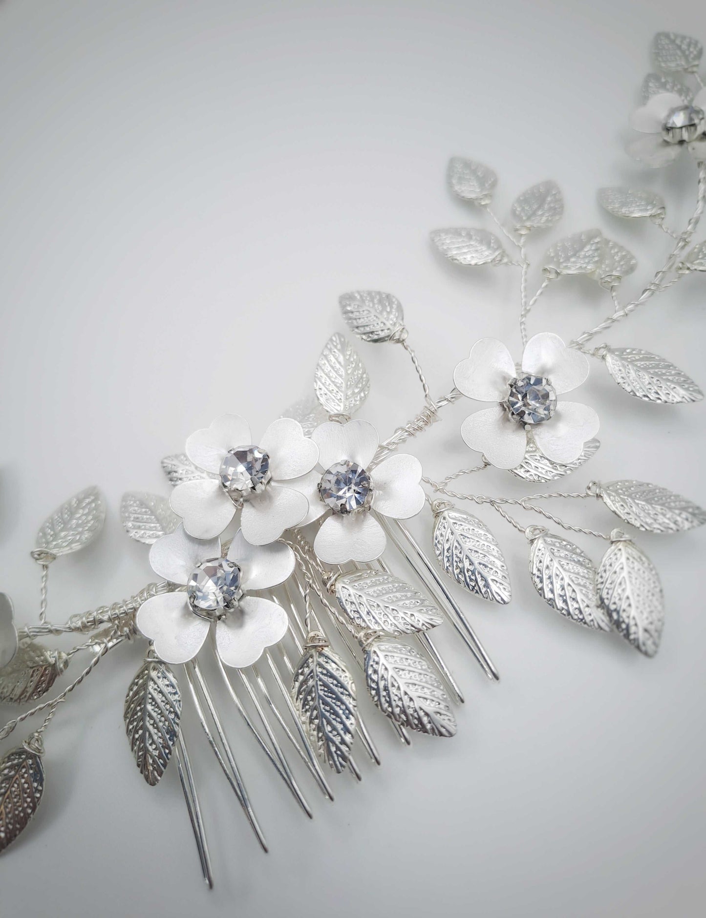 Silver Athena Hairvine bridal hair accessory with intricate leaves and crystal-centered flowers