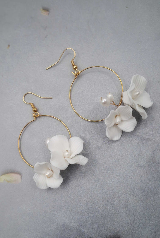 Gold hoop bridal earrings with white ceramic flower dangles