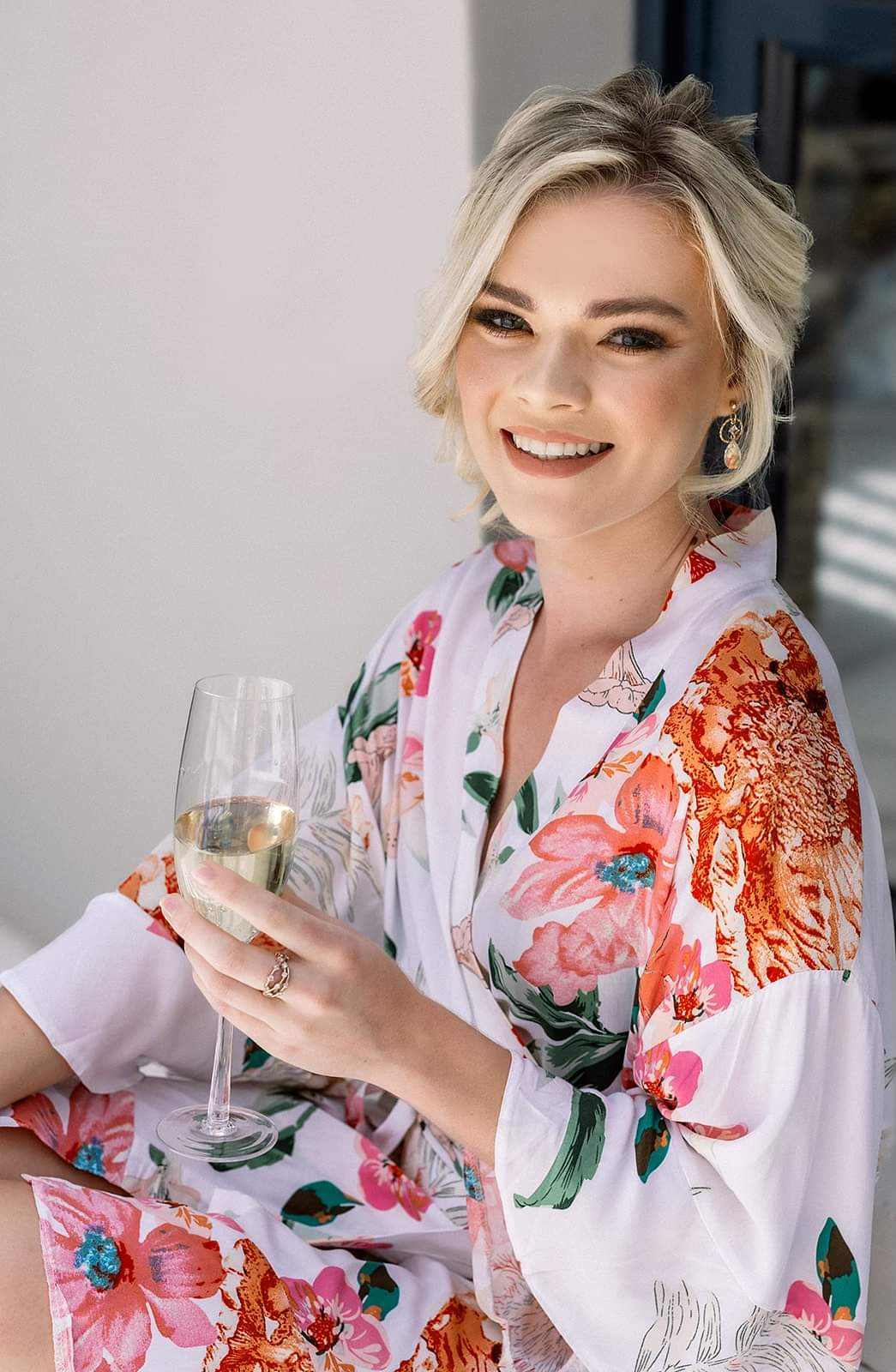 Woman wearing floral cotton gown holding a glass of champagne