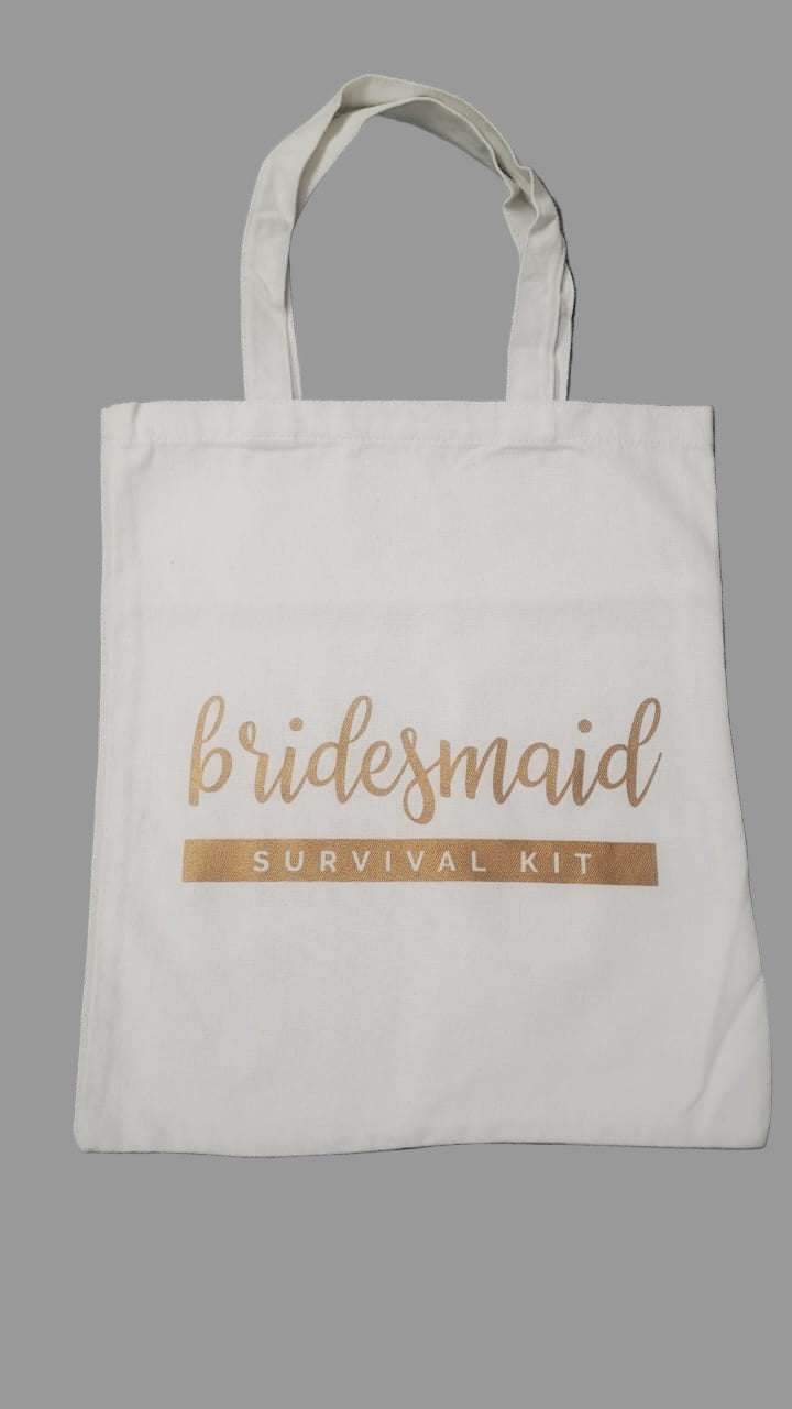 White tote bag with 'bridesmaid survival kit' text on a gray background