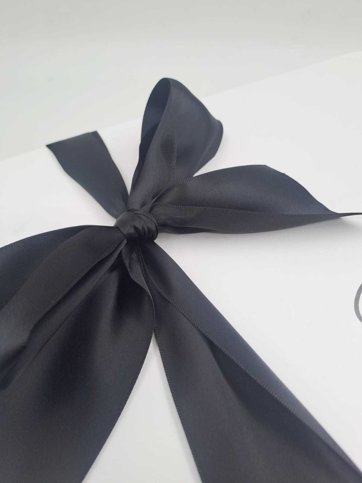 White box with a navy blue ribbon on a white background
