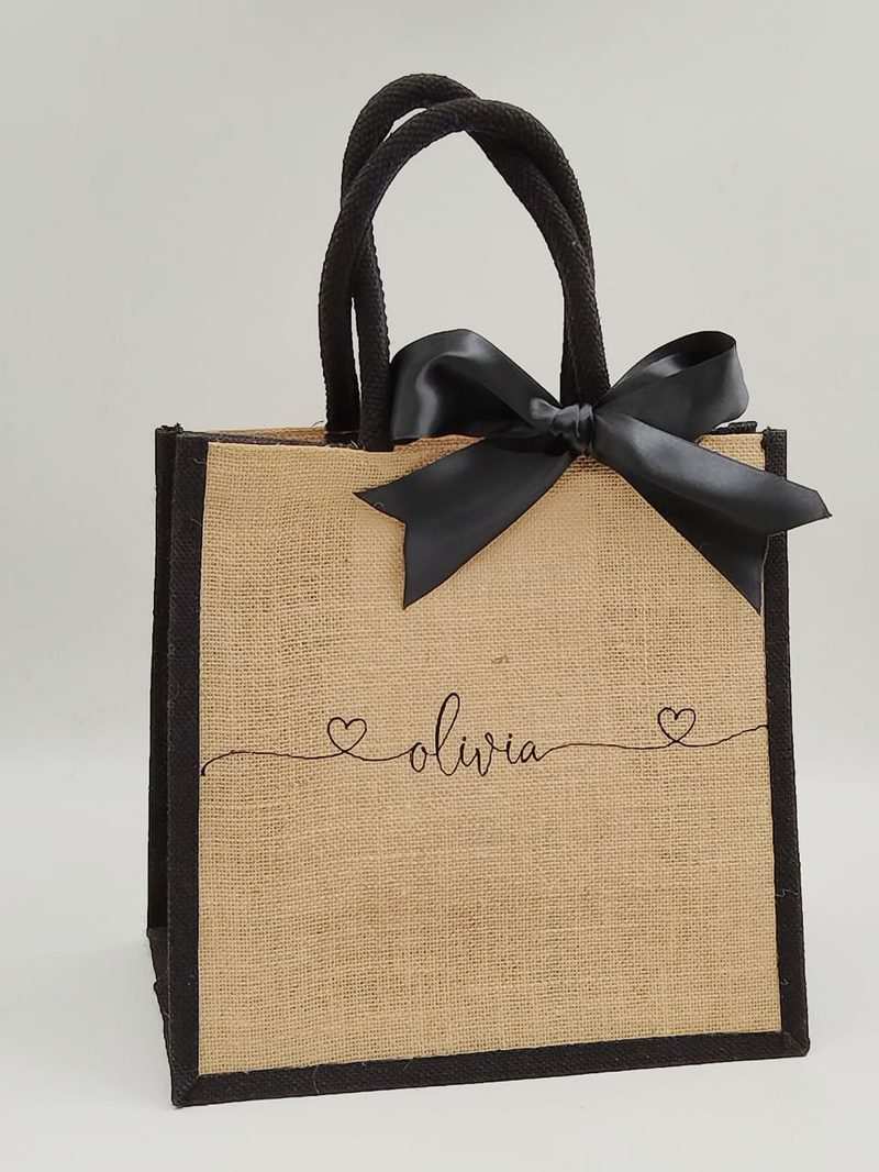 Personalised beach tote made of natural jute with black text and ribbon, spacious and durable for beach essentials