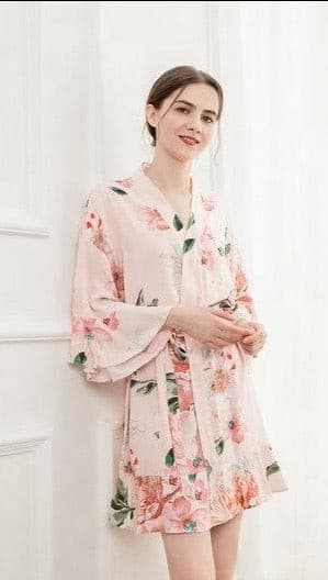 Woman wearing blush pink floral cotton robe standing indoors