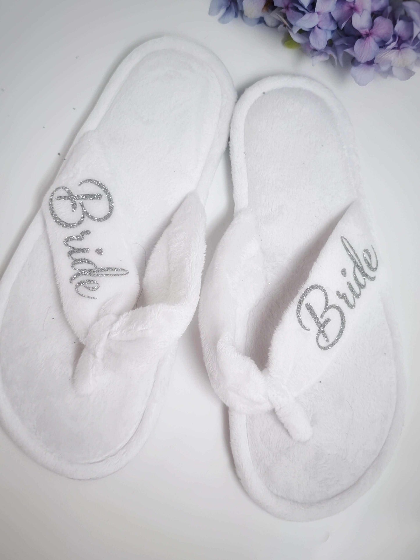 White bridal party towelling thong slippers with "Bride" embroidered in silver, one size fits all, rubber sole, washable