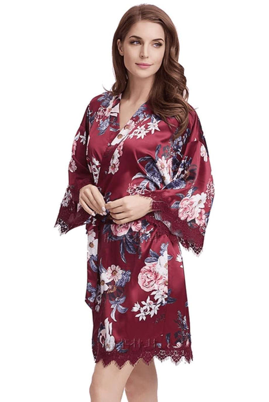Burgundy satin floral robe with lace trim worn by woman, perfect for bridal party.