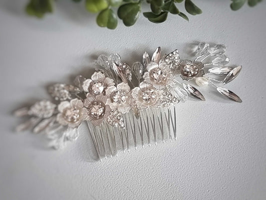 Handmade silver wedding hair comb with intricate flower and leaf details, elegant bridal accessory