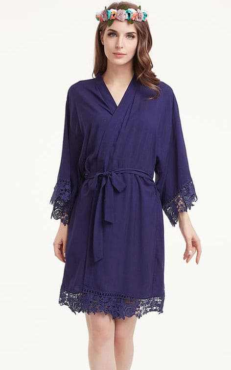 Woman wearing navy cotton robe with lace edges and a waist tie belt