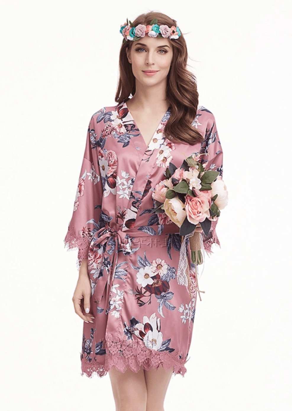 Rose pink satin robe with floral print and lace trim, worn by woman holding bouquet