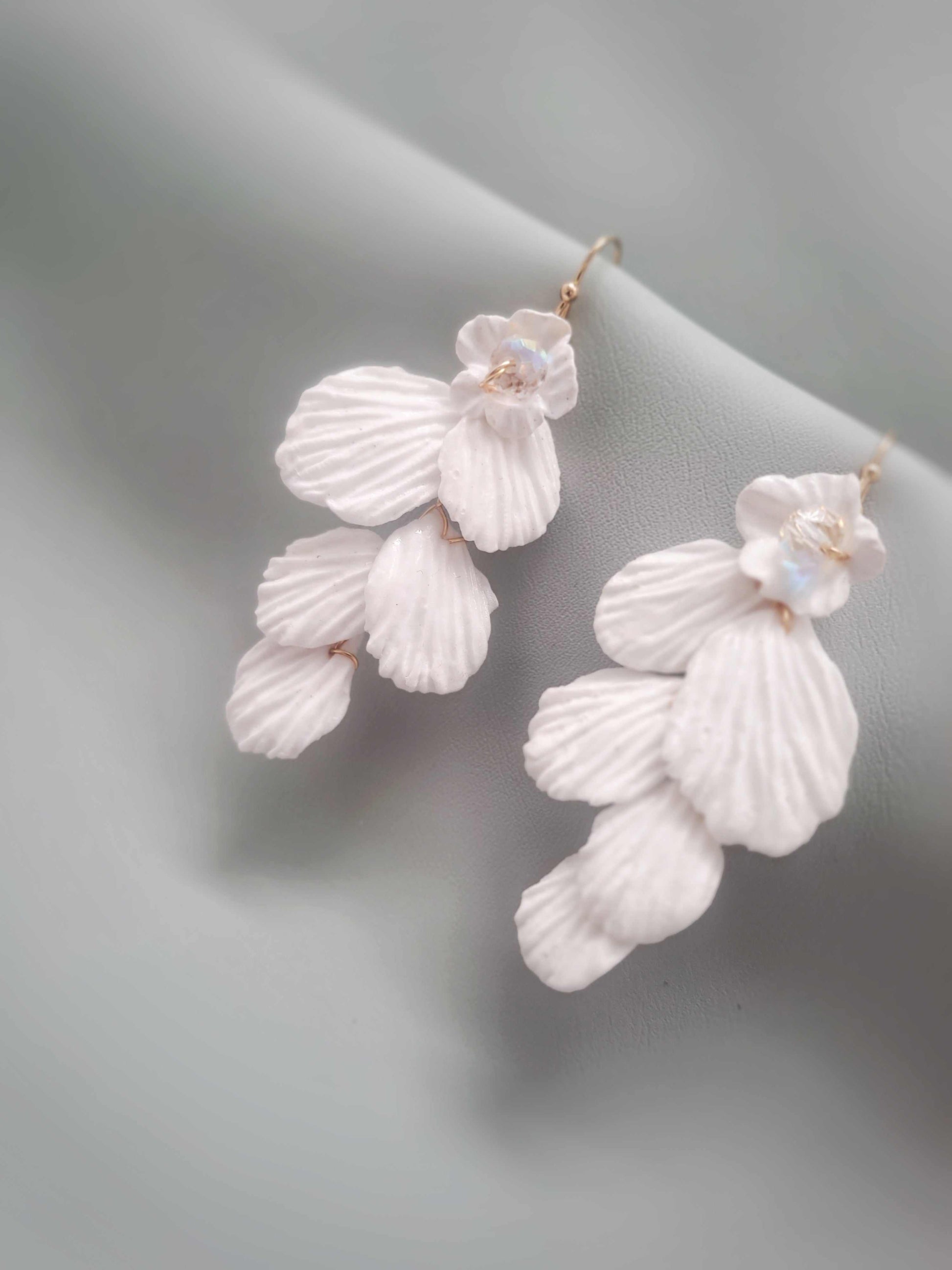 White floral earrings on a light gray background