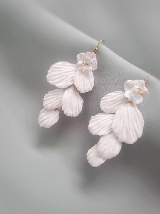 White floral earrings on a light gray background