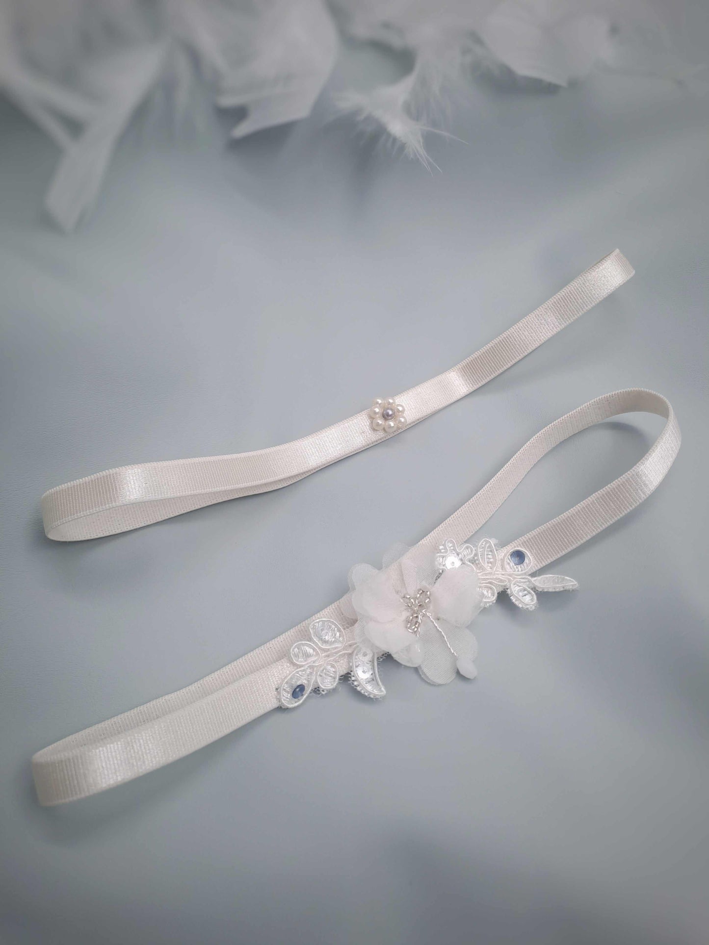 White garterwith floral embellishments on a light blue background