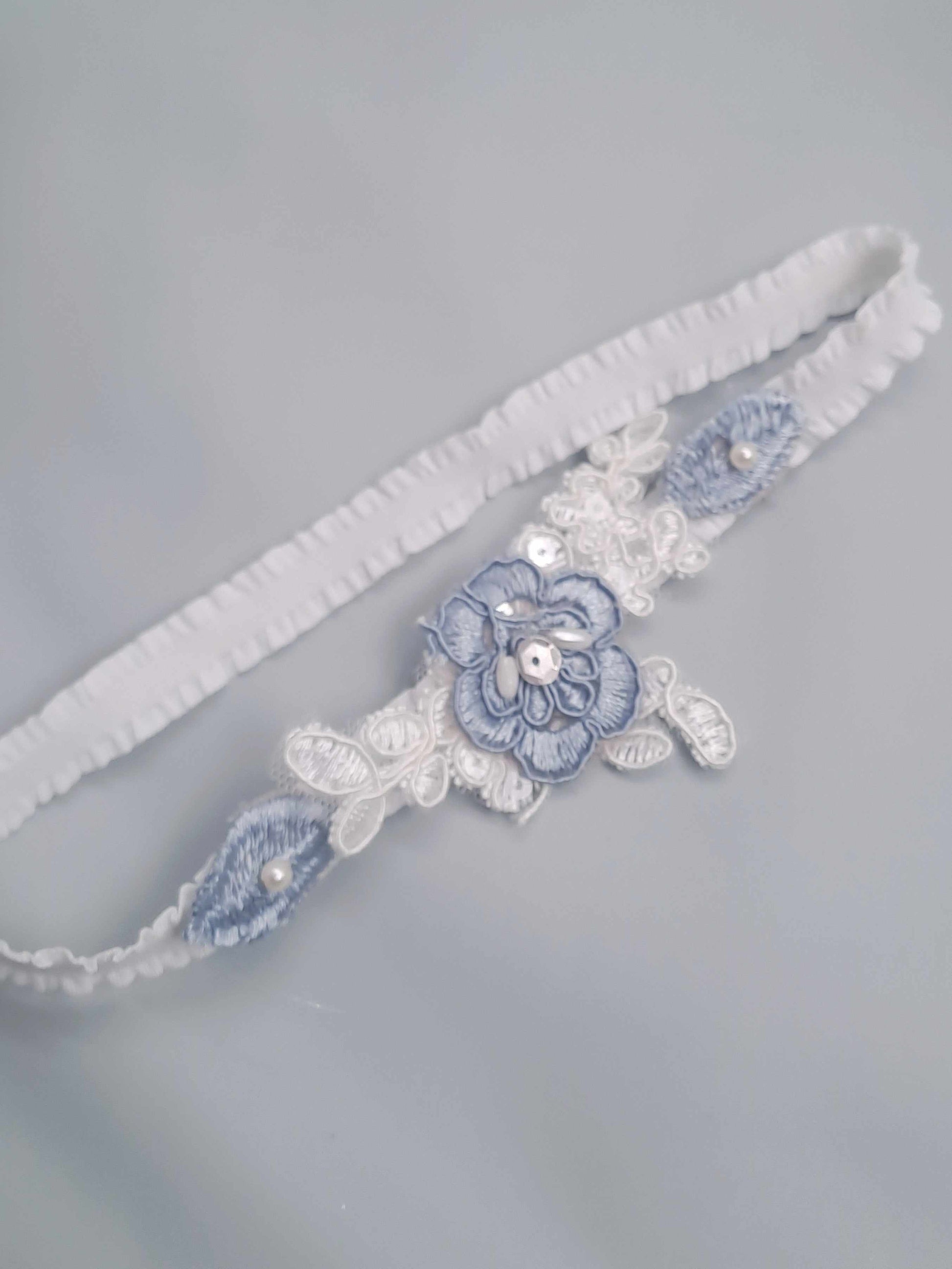 White garter with blue floral design on a gray background
