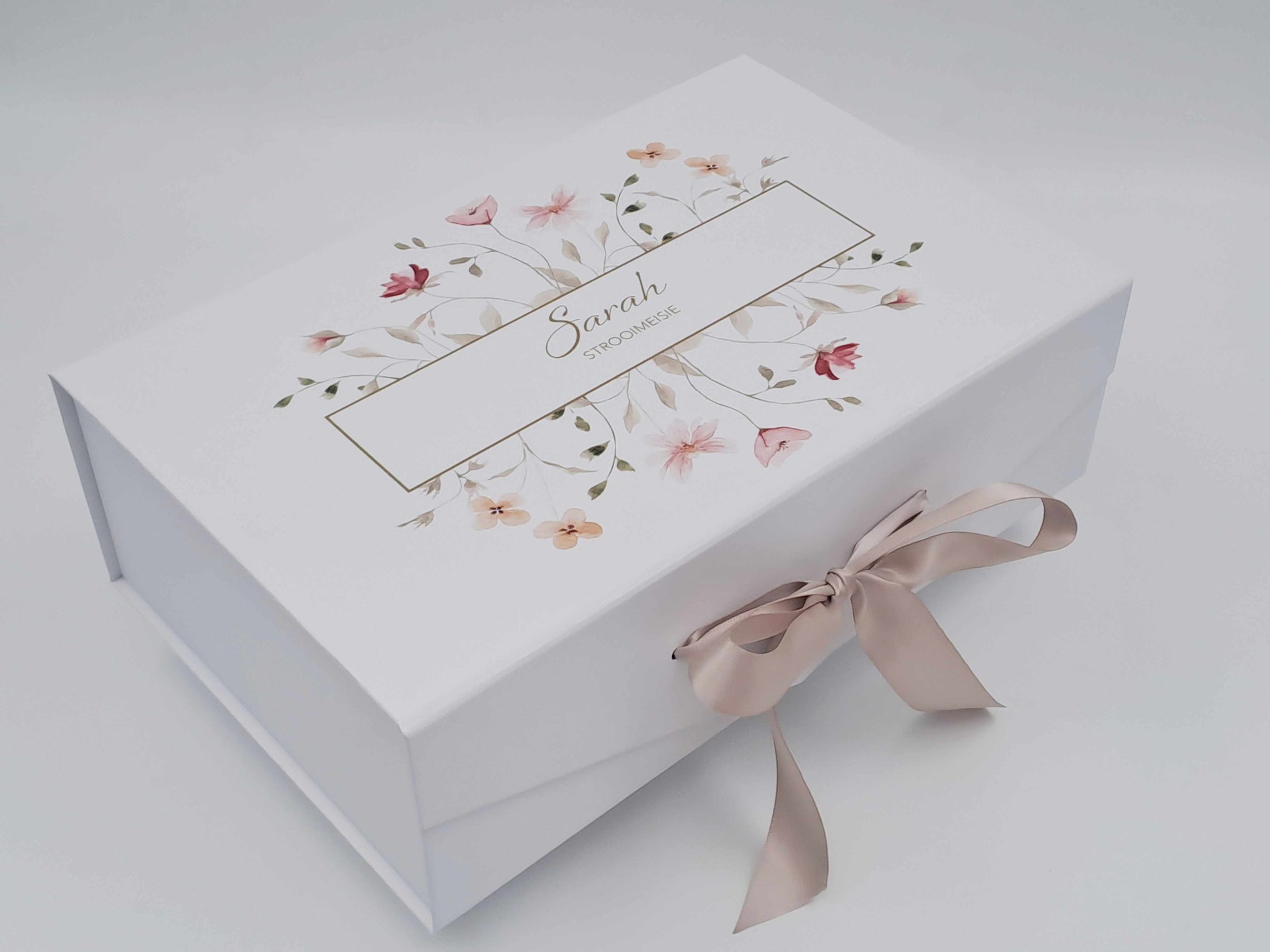 White gift box with floral design and ribbon on a light gray background