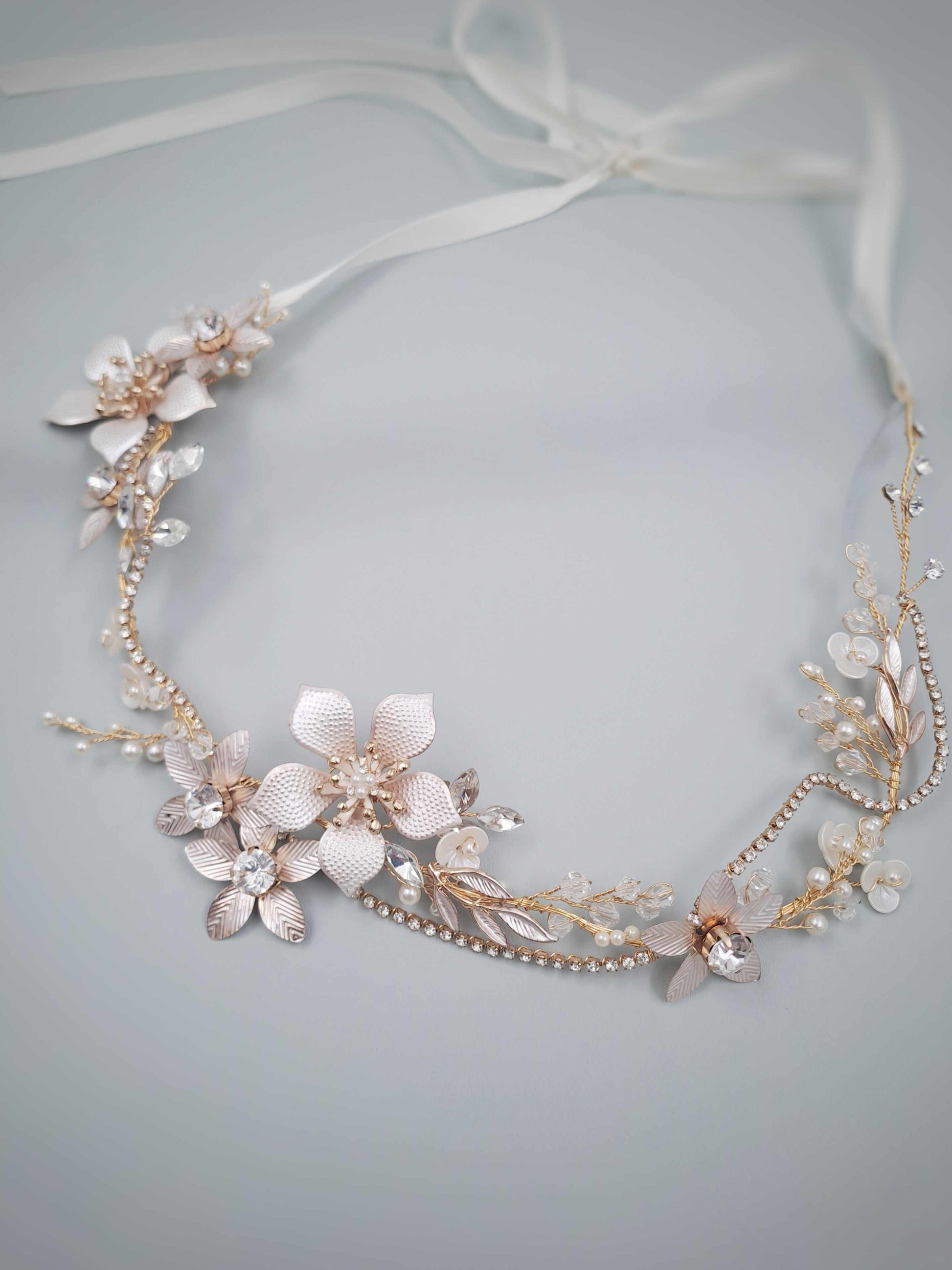 Floral headpiece with gold accents on a light gray background