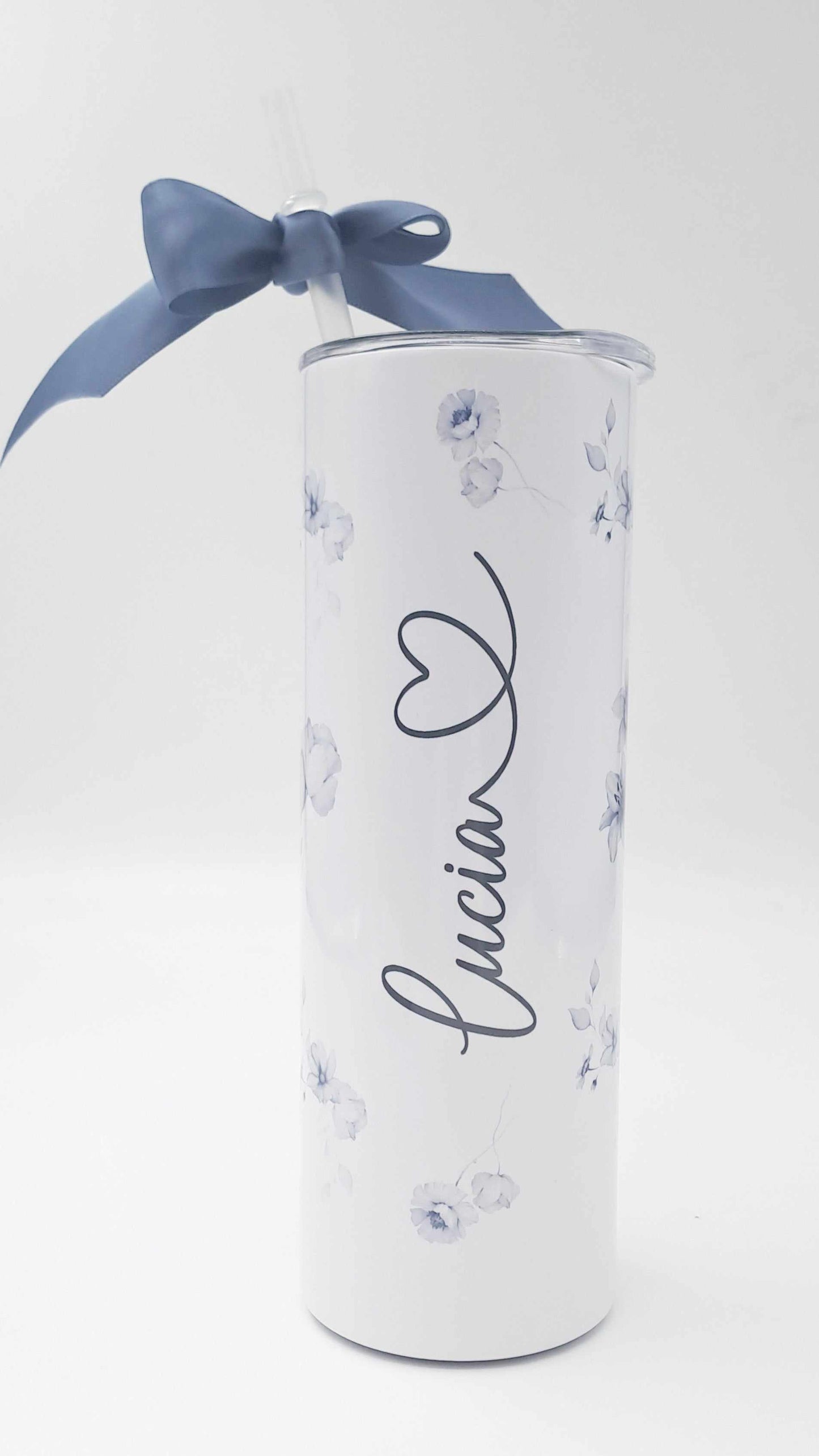 Personalised stainless steel skinny tumbler with floral design, name inscription, included straw, and blue gift ribbon.