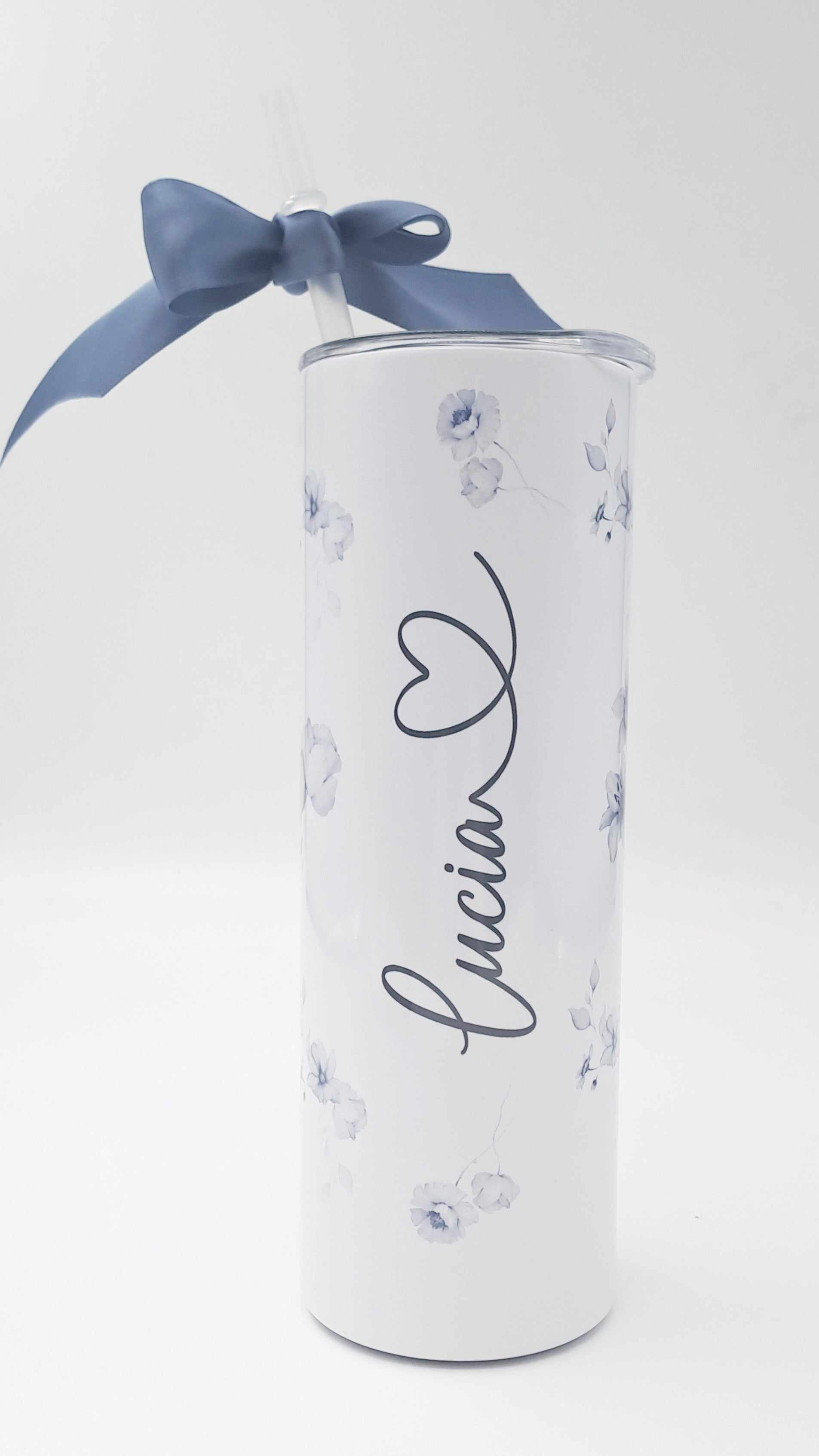 Personalised stainless steel skinny tumbler with floral design, name inscription, included straw, and blue gift ribbon.