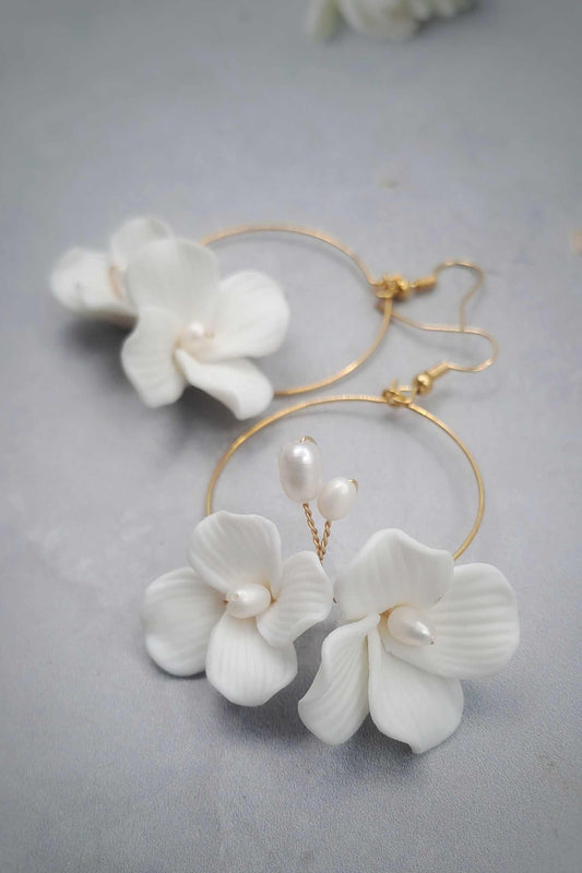 Gold hoop bridal earrings with white ceramic flower and pearl dangle design