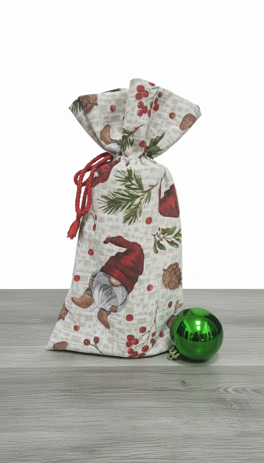 Decorative gift bag with Christmas design on a wooden surface with a green ornament.