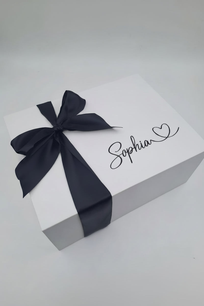 Gift box with a black ribbon and 'Sophia' written on it against a gray background