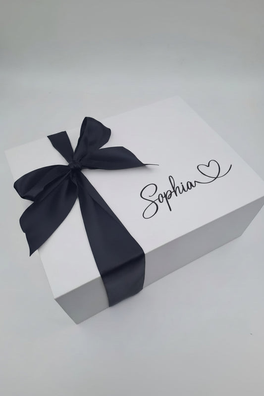 Gift box with a black ribbon and 'Sophia' written on it against a gray background