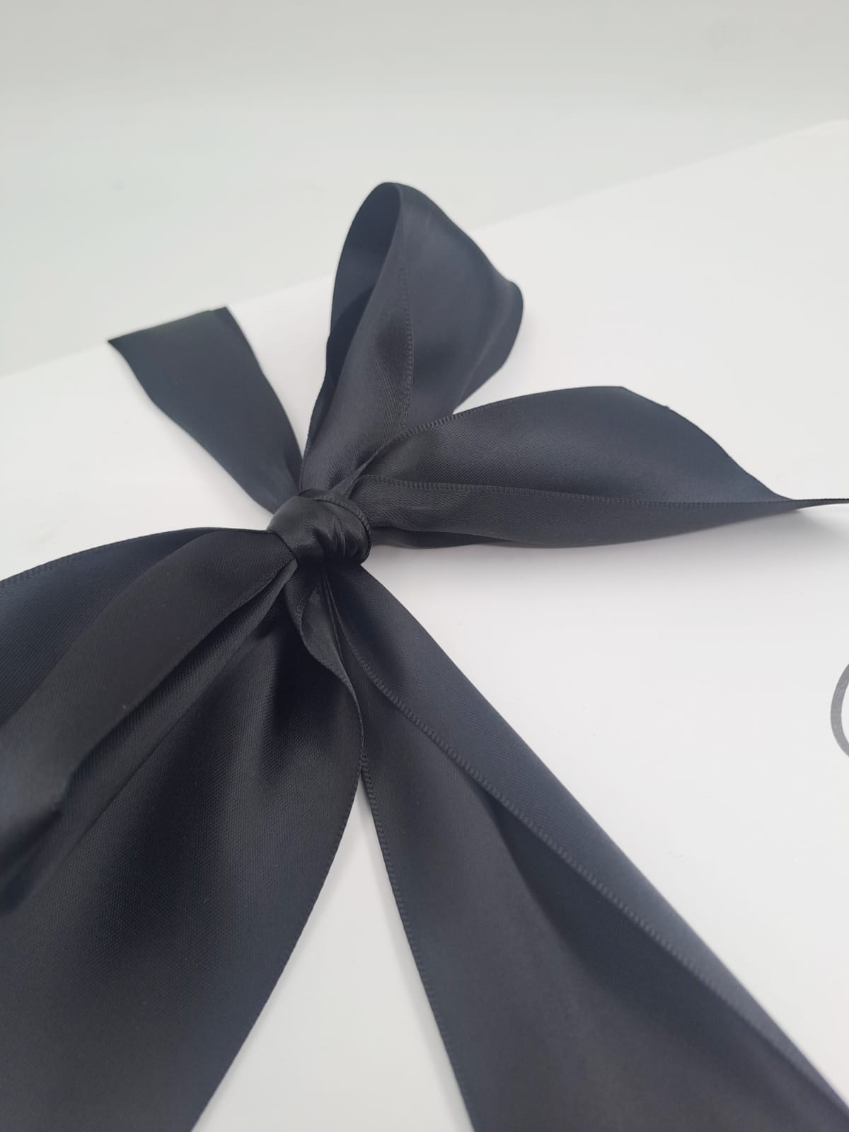 White box with a navy blue ribbon on a white background