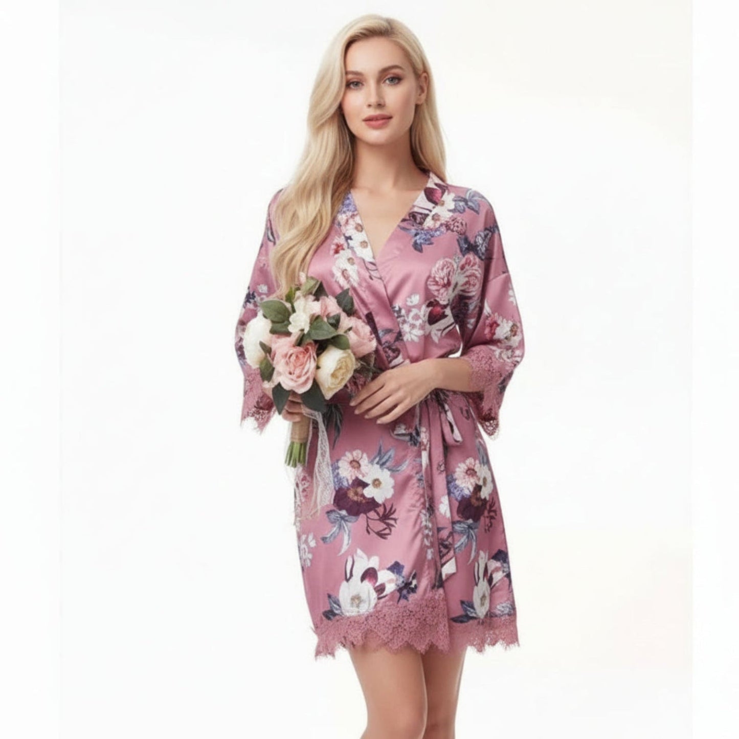 Woman wearing rose pink floral satin robe with lace trim holding bouquet of flowers
