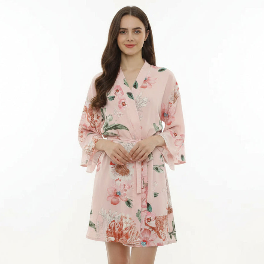 Woman wearing a pink floral robe on a white background