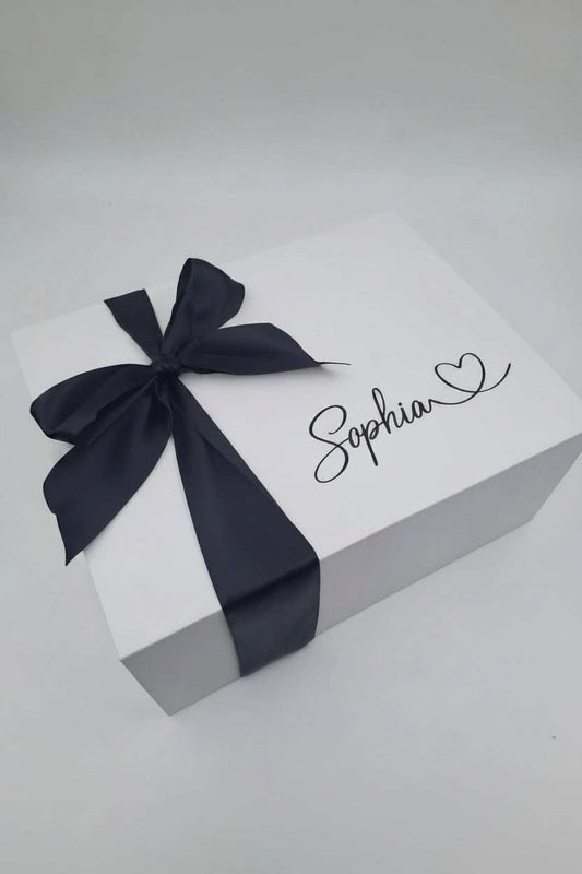 Gift box with a black ribbon and 'Sophia' written on it against a gray background